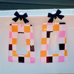 Halloween checkered acrylic earrings with black bow studs and geometric cutout design.