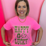 Hot pink graphic tee with green lettering, striped accents, and shamrock detail on soft cotton fabric