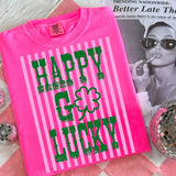 Hot pink graphic tee with green lettering, striped accents, and shamrock detail on soft cotton fabric