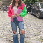 Color block cardigan in hot pink, neon green, and soft lavender with cozy knit texture.