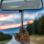 Heart-shaped leather and cowhide reusable car freshener charm designed for re-scenting with fragrance oils.