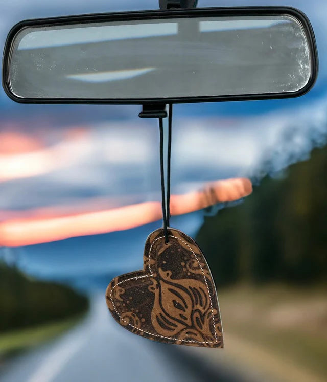Heart-shaped leather and cowhide reusable car freshener charm designed for re-scenting with fragrance oils.