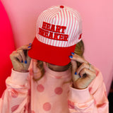 Heart Breaker hat with red lettering and pink striped detail, adjustable snapback canvas cap
