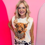 Cream muscle tank with watercolor Highland cow graphic and crystal-inspired jewelry.