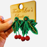 Green layered holly leaf beaded earrings with red berry clusters and gold accents.