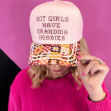 Blush pink hat with Grandma Hobbies lettering, colorful patchwork quilt bill, and gold piping.