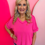 Hot pink corded rib knit top with relaxed fit and hi-low V-neck.