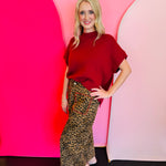 Wide-leg leopard print pants with red stitch pocket detail and elastic waistband.