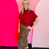 Wide-leg leopard print pants with red stitch pocket detail and elastic waistband.