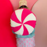 Round pink peppermint swirl pillow, 14-inch diameter, soft and festive holiday decor.