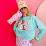 Pink Christmas tumbler with bow-topped holiday treats, hot pink handle, and reusable straw.