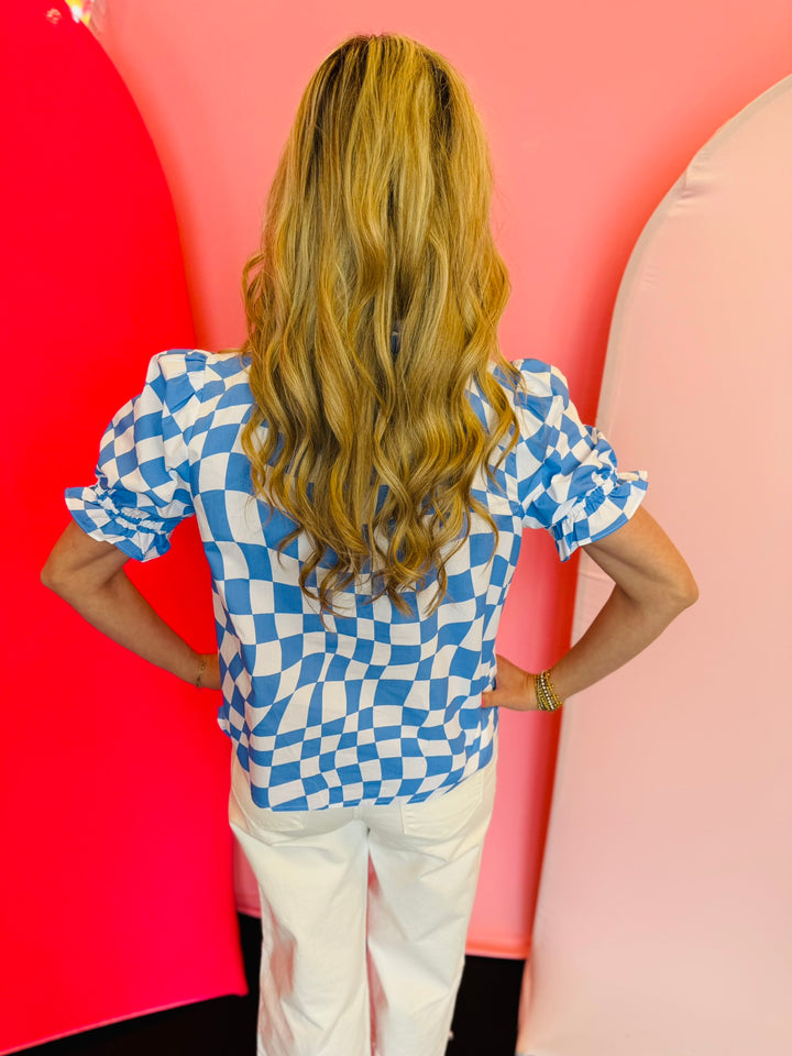 back view of baby blue short puff sleeve top in a baby blue and white checkered top with mock neckline