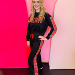 Black “Merry” sweat set with red plaid lettering and matching plaid jogger stripes.