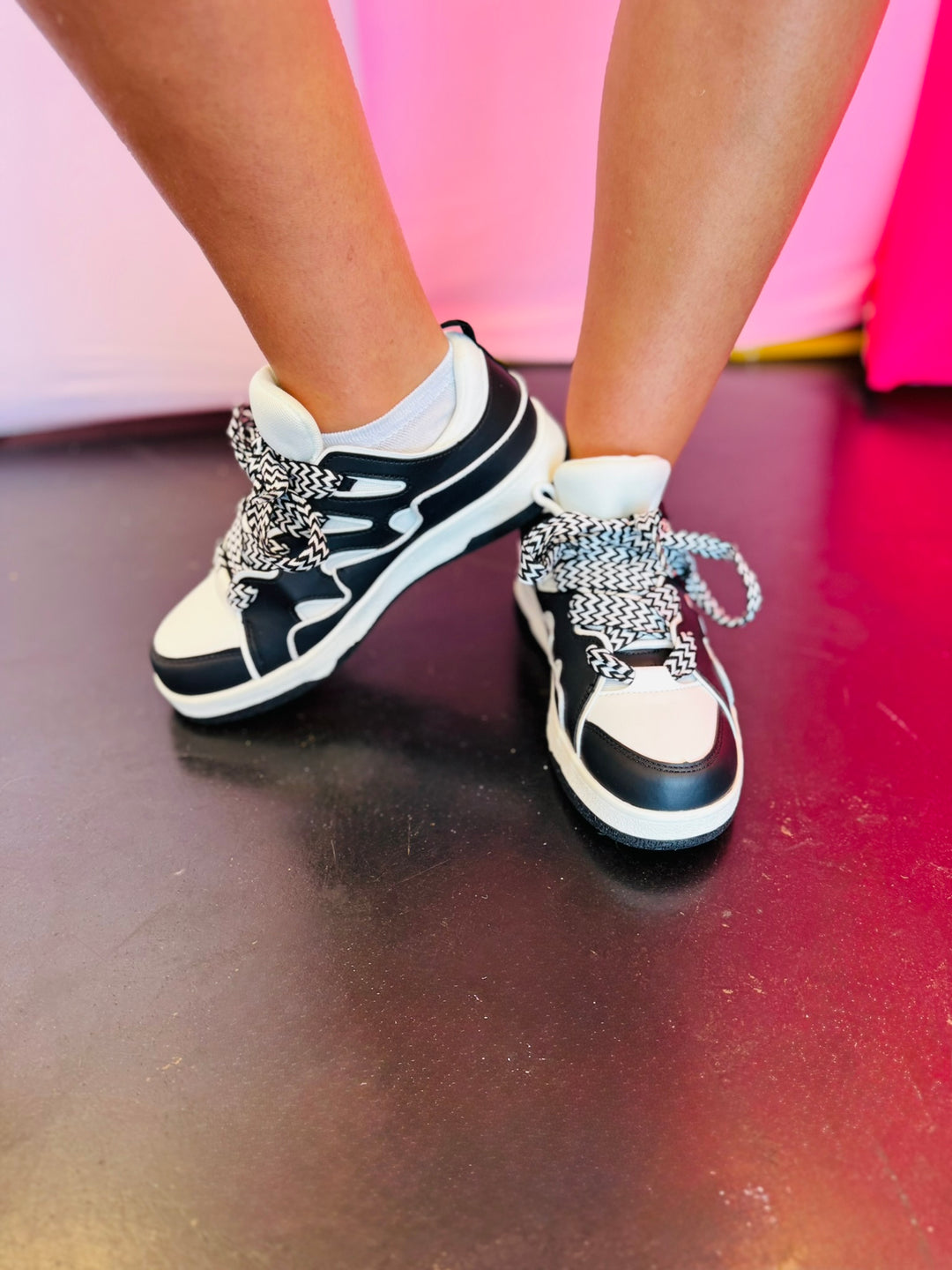 Black and white sneakers with a bold wave design, thick platform sole, and zigzag laces — modern, sporty, and edgy.