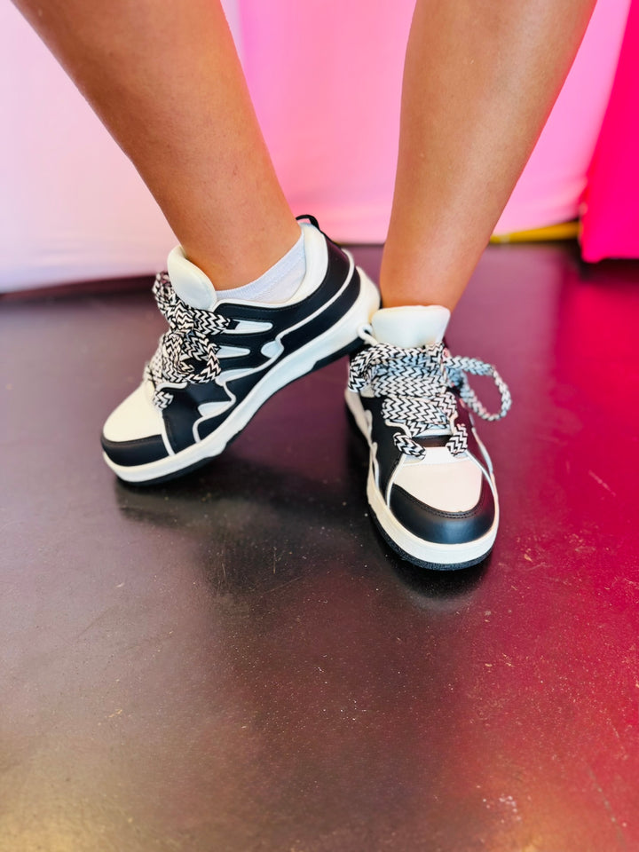 Black and white sneakers with a bold wave design, thick platform sole, and zigzag laces — modern, sporty, and edgy.