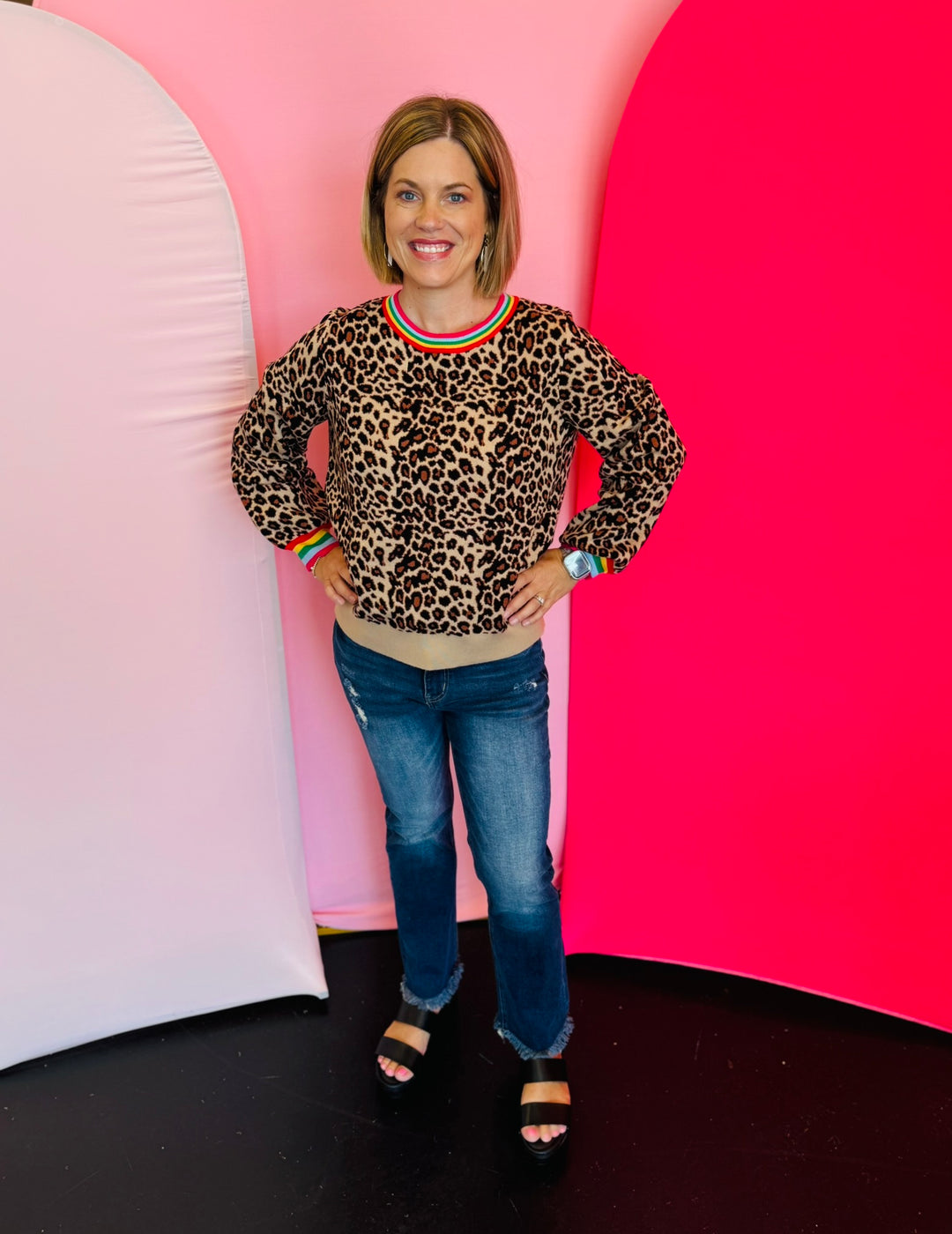 Soft leopard sweater with long puff sleeves, relaxed silhouette, and colorful trim accents on neckline and cuffs.
