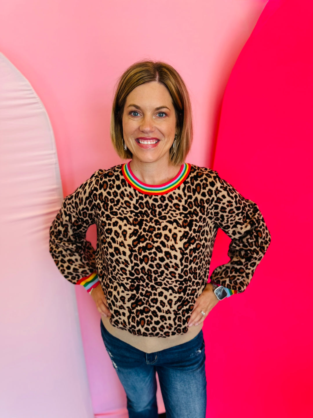 Leopard print knit sweater with vibrant multi-color binding detail along the neckline and cuffs.