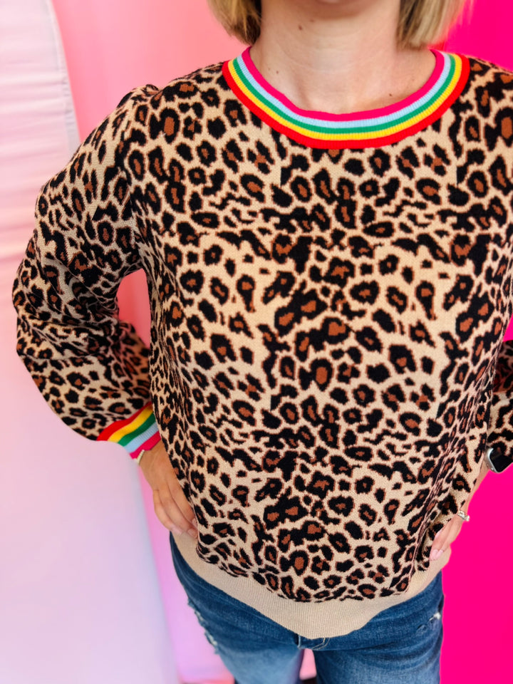 Detailed view of the soft knit leopard fabric showing the puff sleeve construction and multi-color binding at the neckline and cuff.
