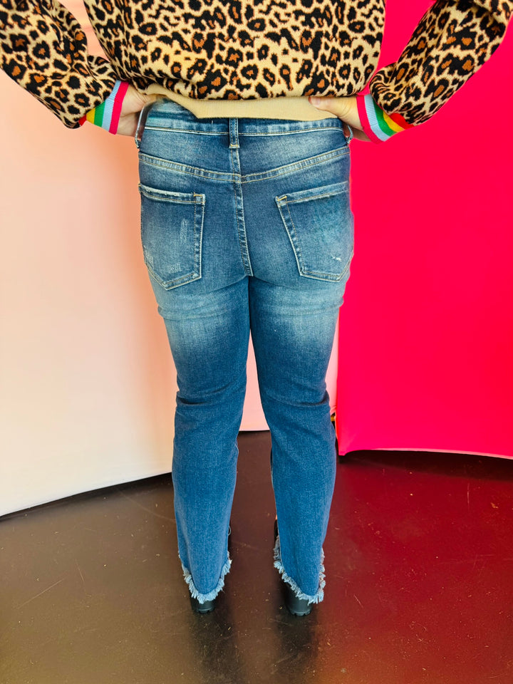 Rear view of cropped denim with high-rise waist, straight-leg fit, and raw hem detail