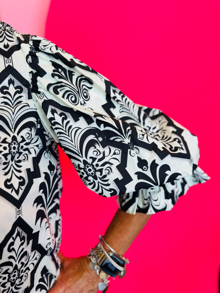3/4 length balloon sleeve with decorative trim at cuff in black damask print.