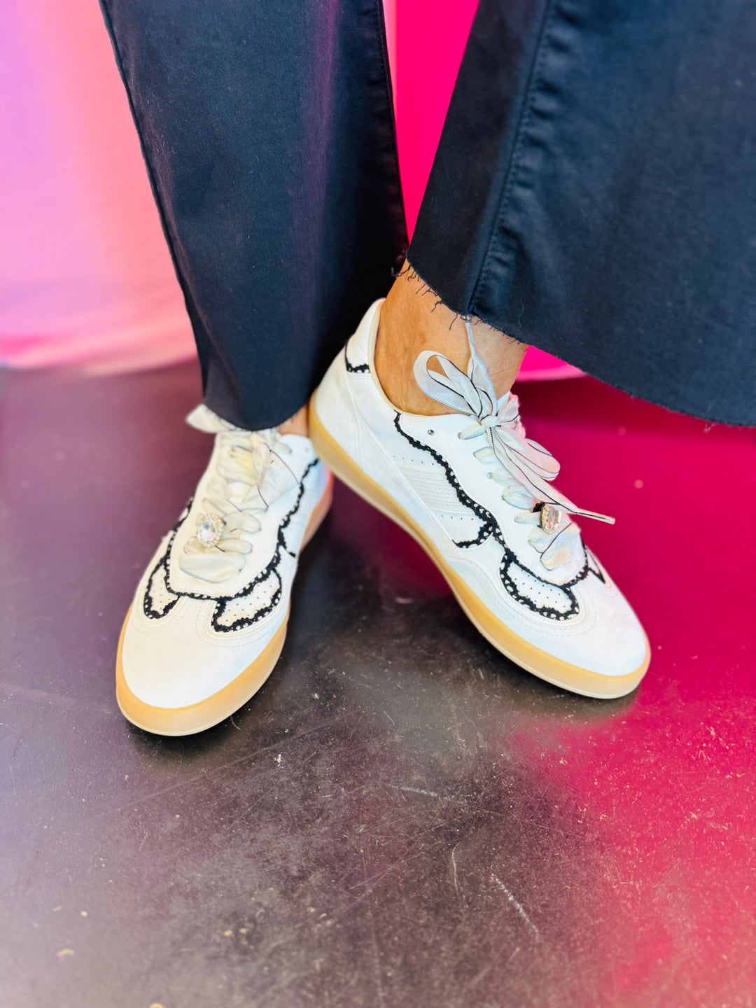 White low-top sneakers with vegan leather upper, delicate lace trim, lace-up closure, and round toe.