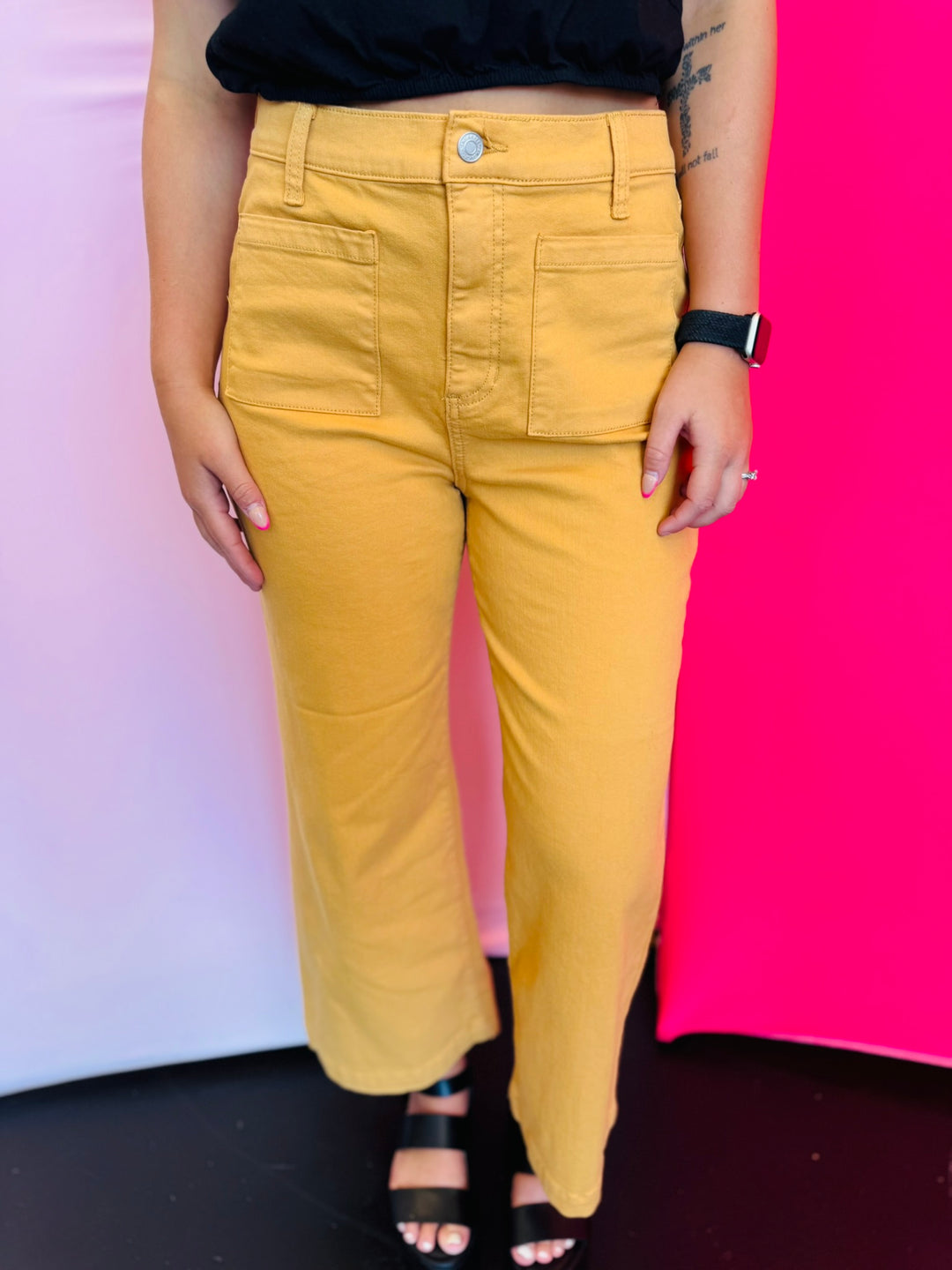 Close view of gold crop wide-leg jeans showing high-rise waistband, wide leg cut, and front pocket detail.