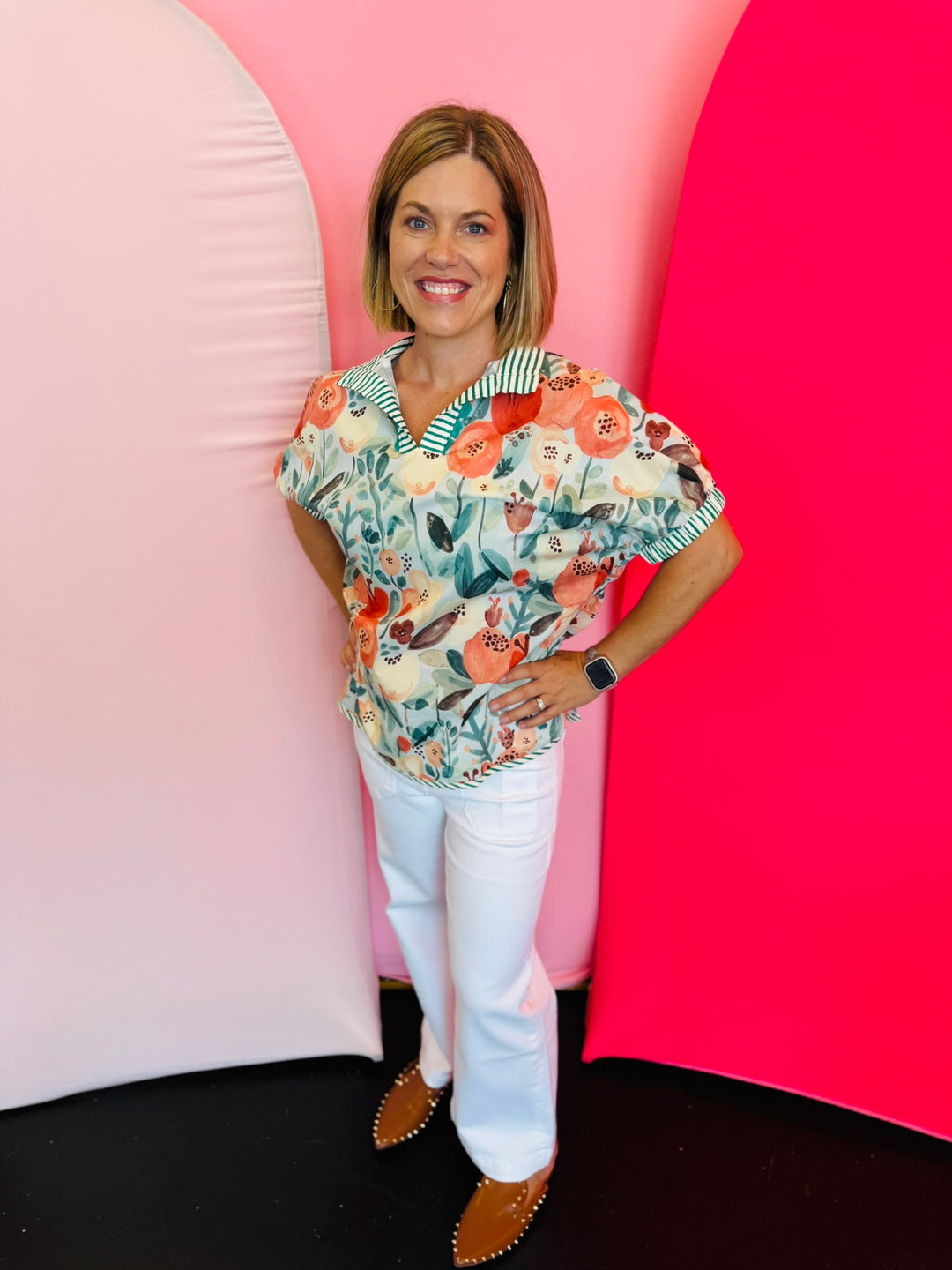 Teal floral mock neck top with coral and peach blooms, striped split neckline with decorative trim, and relaxed short puff sleeves.