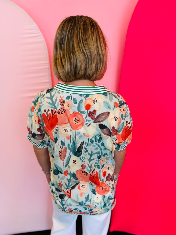 Rear view of teal floral top showing continuous floral print and relaxed fit.