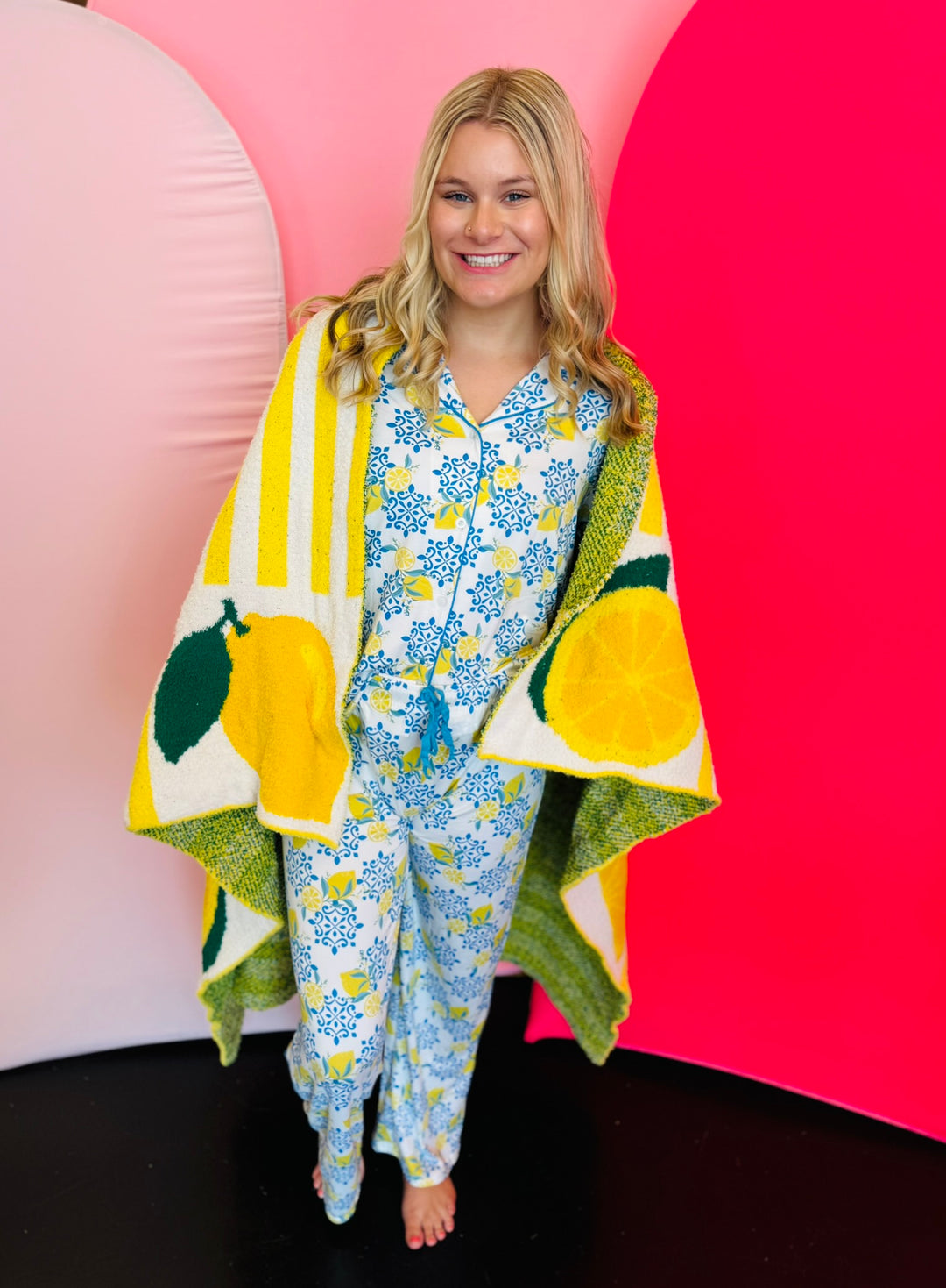 Soft blanket with playful allover lemon print in yellow and green on a white background.