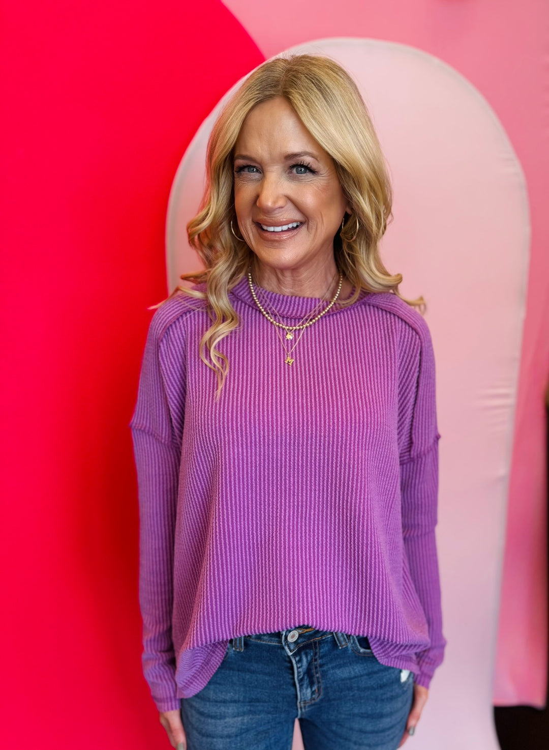 Light plum ribbed boat neck top with raw edge detailing, long sleeves, and relaxed fit.