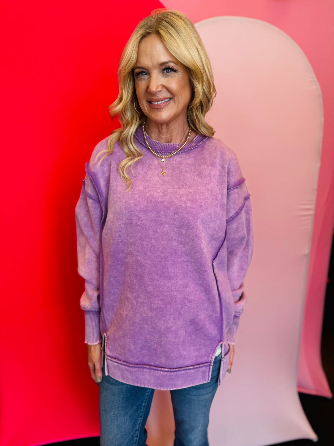 Violet acid wash fleece sweatshirt with exposed seams, relaxed fit, and side slits.