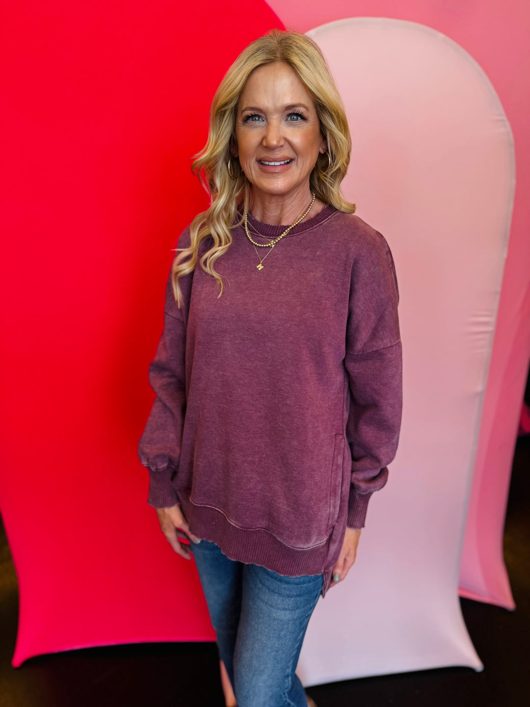 Eggplant acid wash fleece sweatshirt with exposed seams, relaxed fit, and side slits.