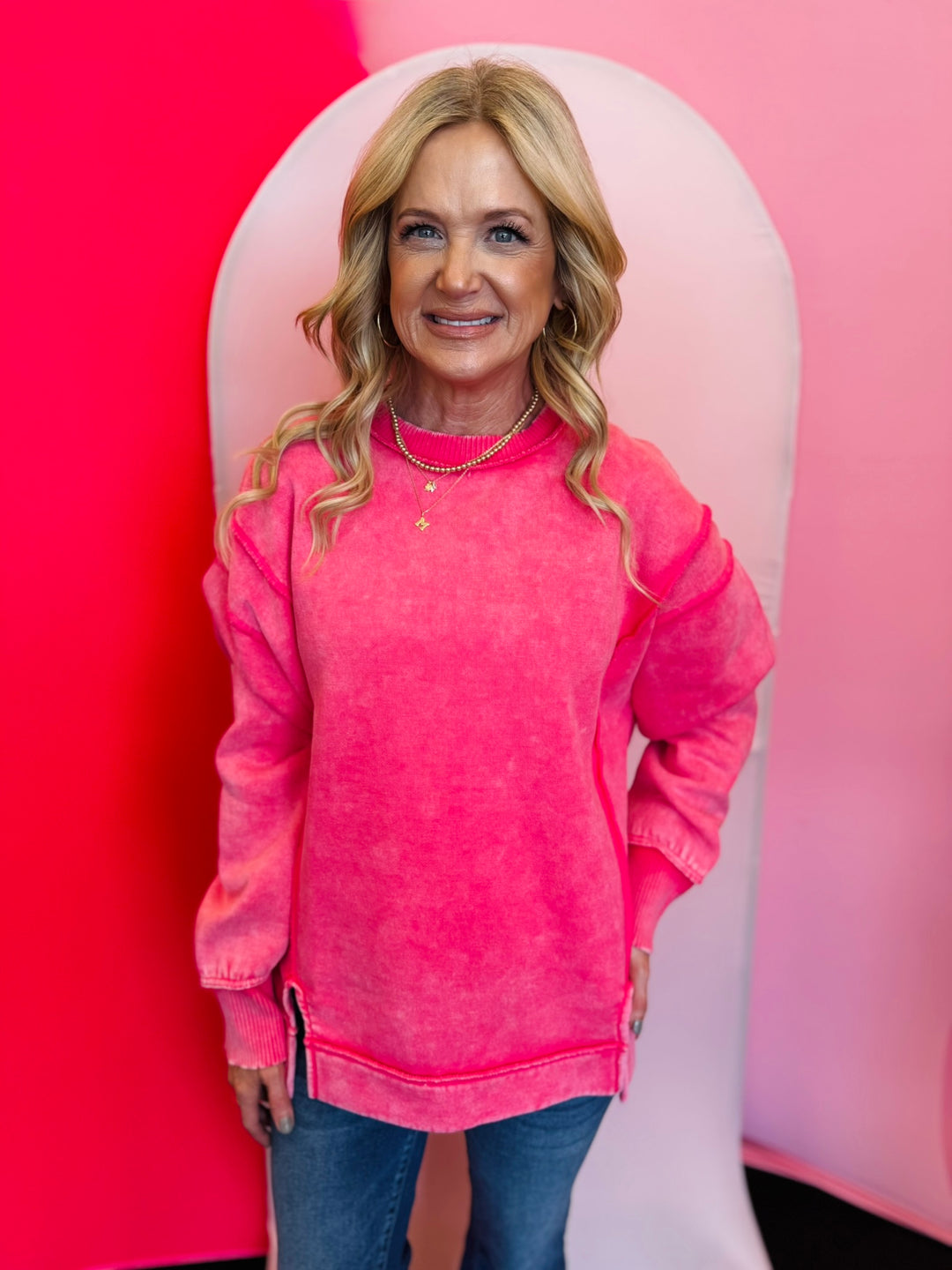 Fuchsia acid wash fleece sweatshirt with exposed seams, relaxed fit, and side slits.