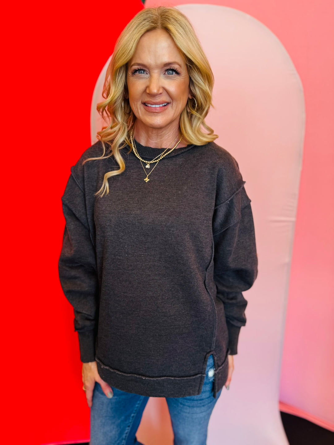 Black acid wash fleece sweatshirt with exposed seams, relaxed fit, and side slits.