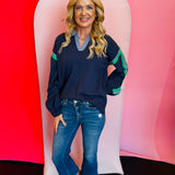 navy knit pullover with a blue collar and green stripes on long sleeves.