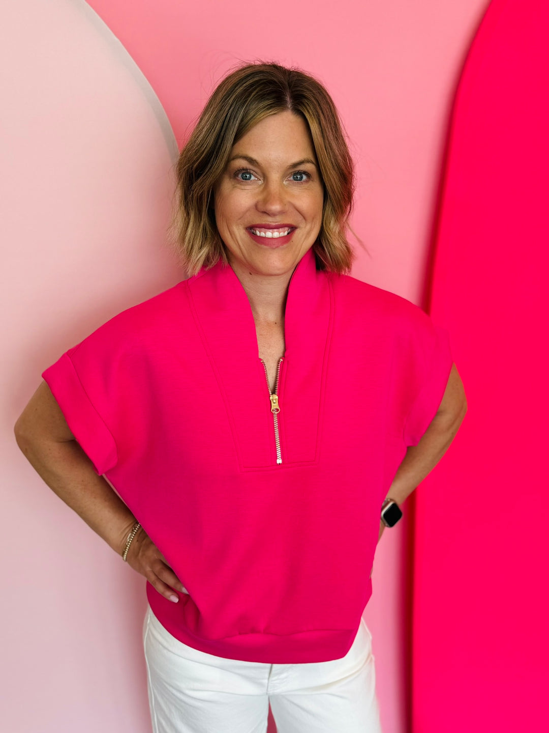 Hot pink half-zip high neck top with a soft, smooth finish, styled for a cozy yet trendy summer look.