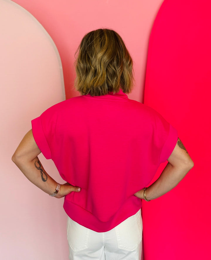 Hot pink half-zip high neck top with a soft, smooth finish, styled for a cozy yet trendy summer look.