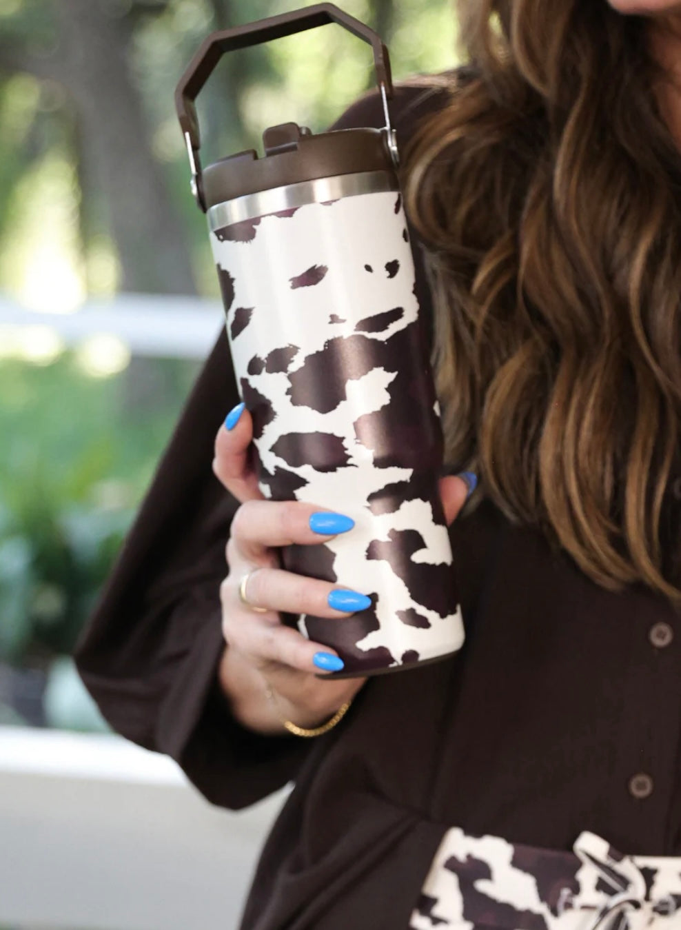 30oz chocolate cow print travel tumbler with screw-on lid, handle, and car cup holder–friendly design.