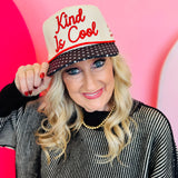 Cream snapback hat with "Kind is Cool" embroidery, black polka-dotted bill, and red hearts on the back.