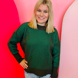 Dark olive two-tone sweater with exposed seams, hi-low hem, and contrasting ribbed trim.