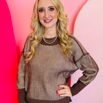 A relaxed-fit, brown and white striped sweater with long sleeves. The sweater has visible exposed seams, a hi-low hemline, and side slits.