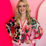 Oversized cardigan with heart, leopard, and mixed patterns in pink, green, beige, and black.