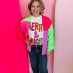 Color block cardigan in hot pink, neon green, and soft lavender with cozy knit texture.