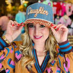 Poppy and Pine Denim-blue “Daughter” hat with brown polka dot bill, cream trim, and “of the King” side embroidery.