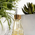 Thomas Blonde - small, elegant bottle of pre-toilet drops with visible 24-karat gold flakes floating inside.