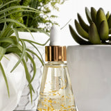 Thomas Blonde - small, elegant bottle of pre-toilet drops with visible 24-karat gold flakes floating inside.