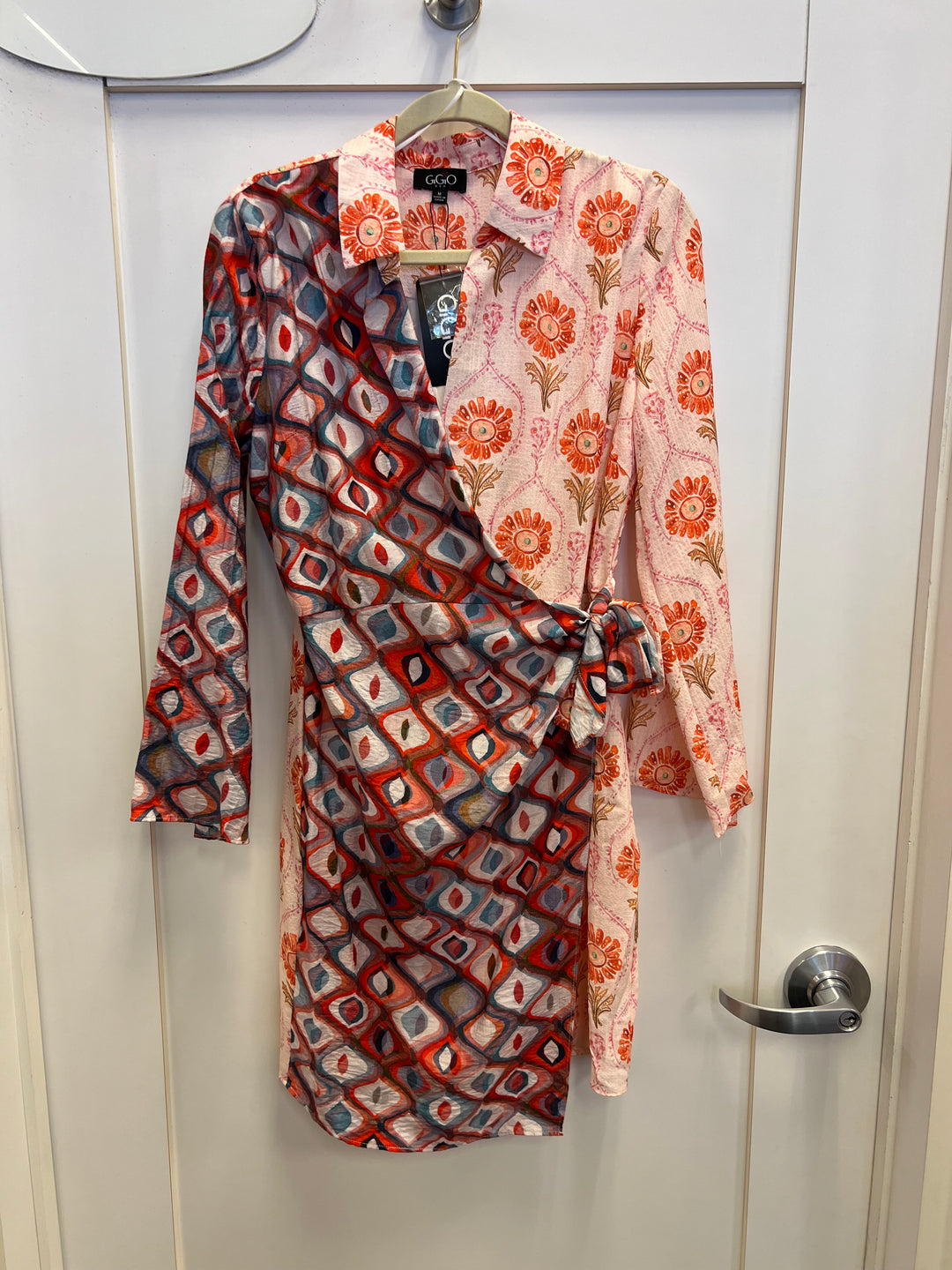Red and coral mixed print long sleeve wrap mini dress with a collar and tie waist.