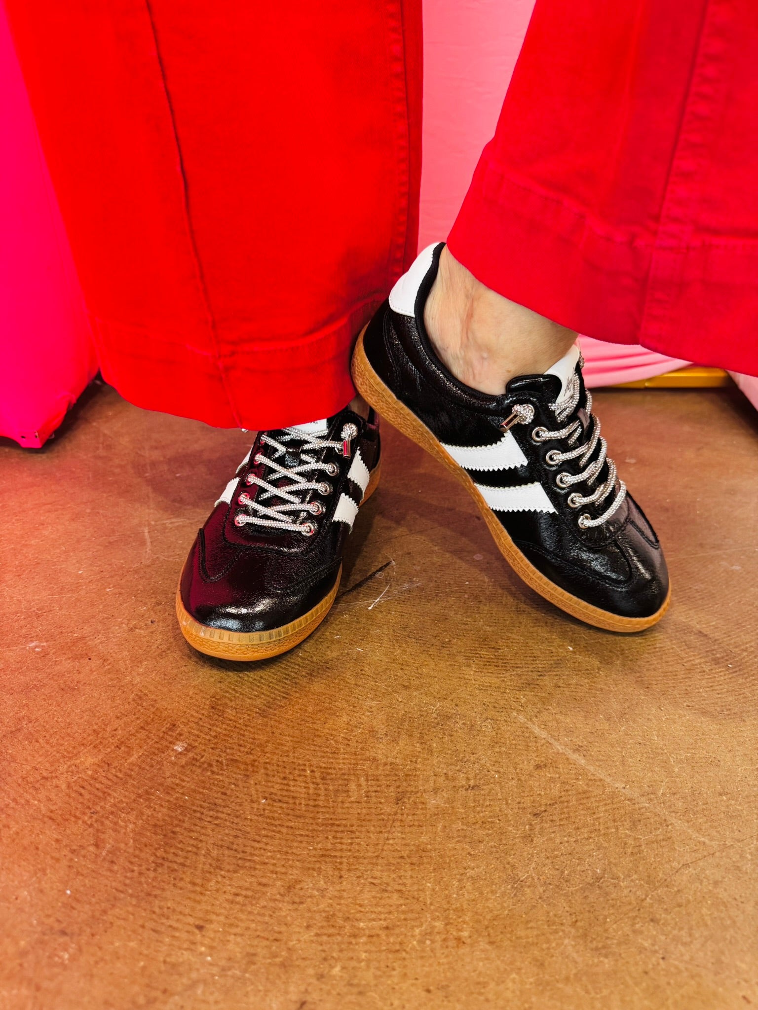 Black metallic Corky's sneakers with white side stripes and lace-up closure.