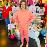 Coral colored crossover waistband leggings with sleek design 