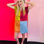 Bright autumn colorblock mini dress with burgundy, mustard, orange, and light blue panels, short sleeves, and a V-notch neckline.